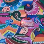 Colourful homemade rangoli design arranged on a floor for Diwali.