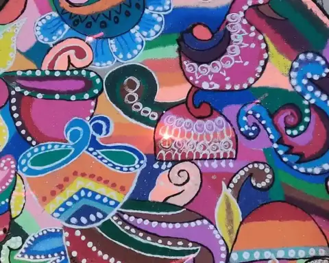 Colourful homemade rangoli design arranged on a floor for Diwali.
