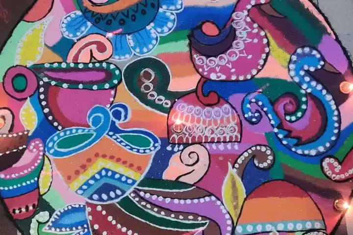 Colourful homemade rangoli design arranged on a floor for Diwali.