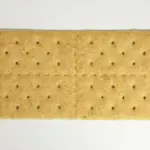 Stack of plain rectangular graham crackers on a white background.