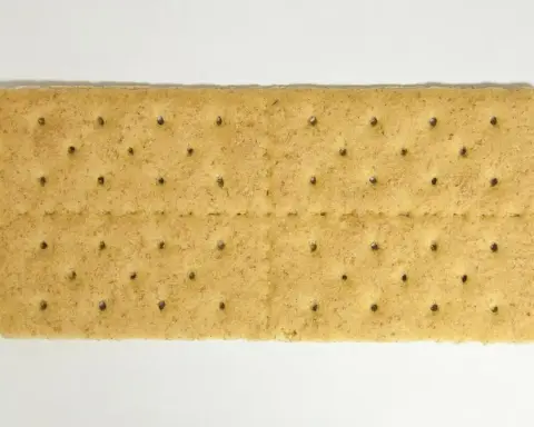 Stack of plain rectangular graham crackers on a white background.
