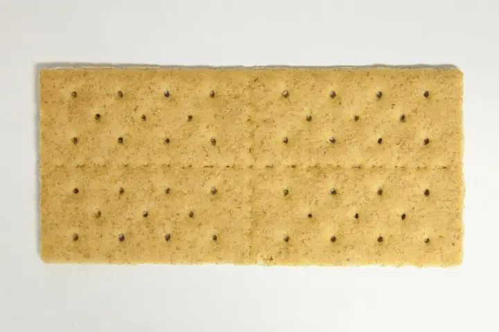 Stack of plain rectangular graham crackers on a white background.