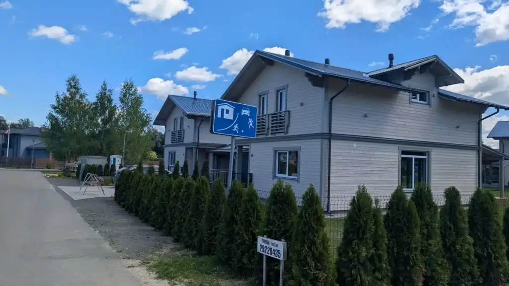 Photograph of a residential home with a real estate sign outside.