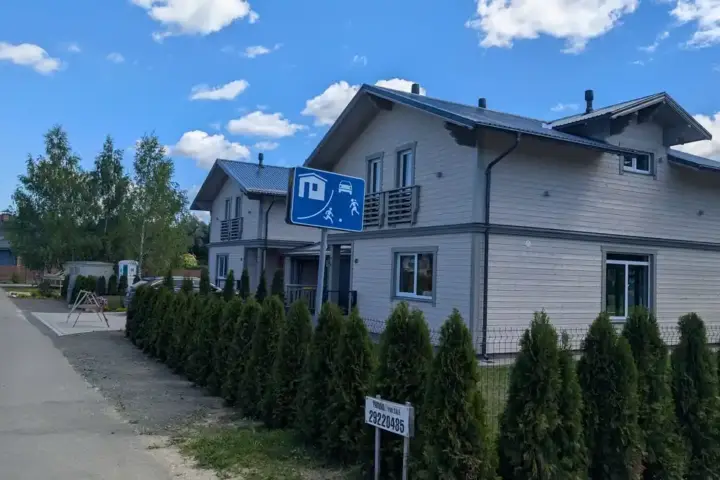Photograph of a residential home with a real estate sign outside.