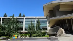 Daytime architectural photograph showing the glass facade, entrance, and landscaping of Building 92 at the Microsoft corporate campus in Redmond, Washington.