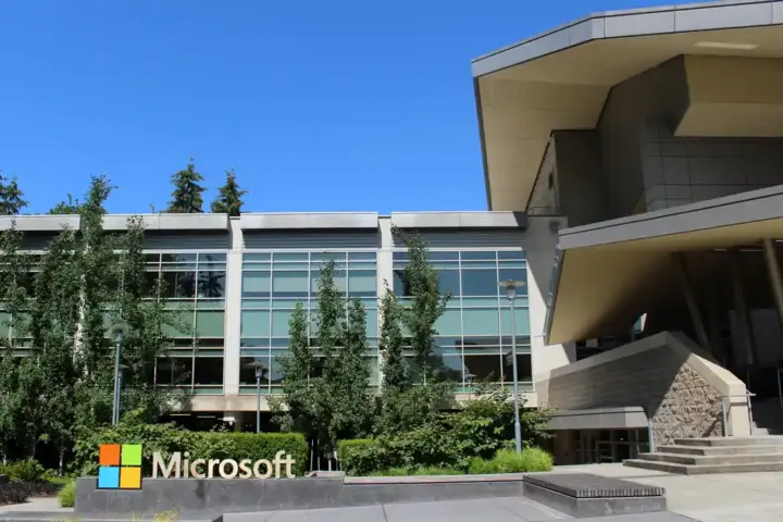 Daytime architectural photograph showing the glass facade, entrance, and landscaping of Building 92 at the Microsoft corporate campus in Redmond, Washington.
