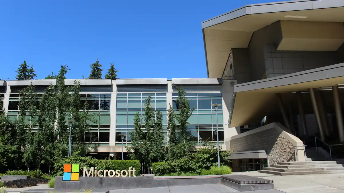 Daytime architectural photograph showing the glass facade, entrance, and landscaping of Building 92 at the Microsoft corporate campus in Redmond, Washington.