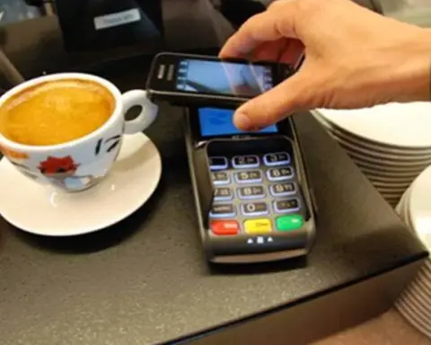 Close-up photograph of a user holding a smartphone during a digital payment transaction.