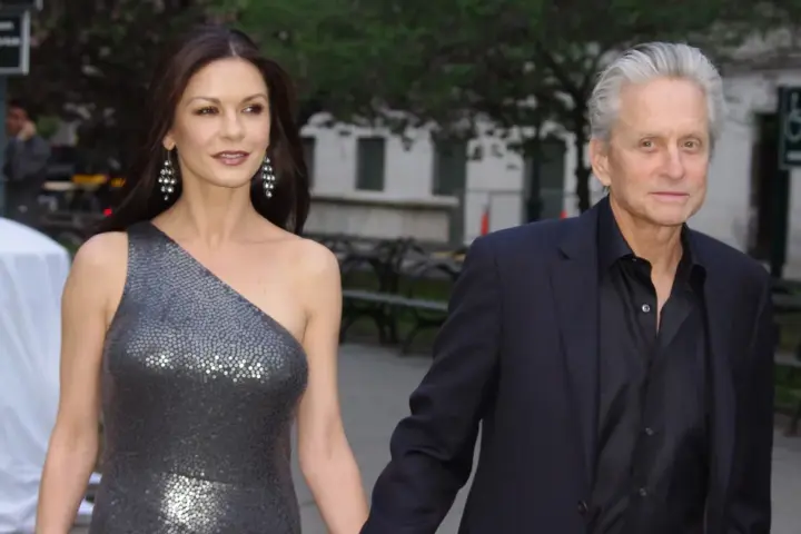 Red carpet photograph of actors Catherine Zeta-Jones and Michael Douglas standing together at a public film event.
