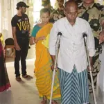 Security personnel assisting a voter at a polling booth in West Bengal during India’s 2024 general election.