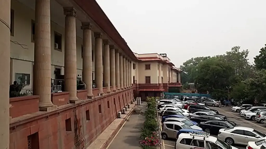 Frontal exterior view of the red sandstone and white central dome of the Supreme Court of India building in New Delhi.