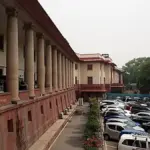 Frontal exterior view of the red sandstone and white central dome of the Supreme Court of India building in New Delhi.