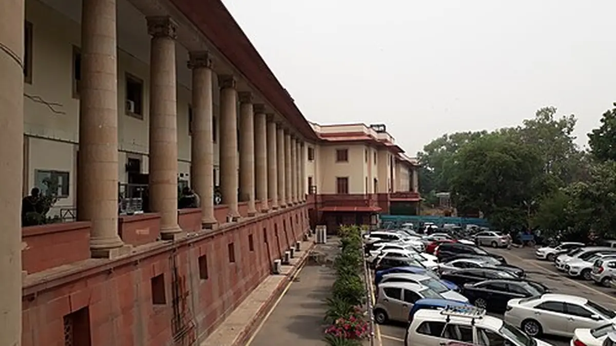 Frontal exterior view of the red sandstone and white central dome of the Supreme Court of India building in New Delhi.