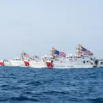 Three U.S. Coast Guard fast-response cutters travel through the Strait of Hormuz.