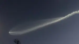 SpaceX Falcon 9 second-stage rocket exhaust plume glowing against the twilight sky, forming an expanded jellyfish-shaped cloud.