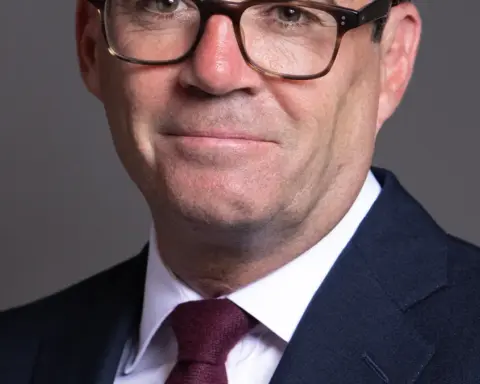 Official portrait photograph of British Prime Minister Andy Burnham in formal parliamentary attire.