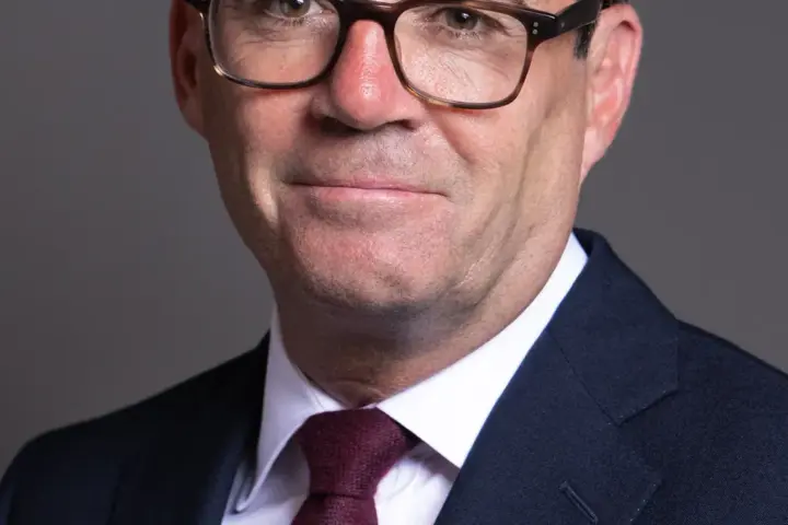 Official portrait photograph of British Prime Minister Andy Burnham in formal parliamentary attire.