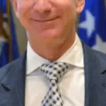 Close-up photograph of Amazon and Blue Origin founder Jeff Bezos speaking during an official policy and industry presentation.