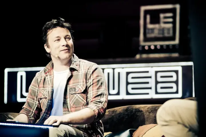 Photograph of Jamie Oliver speaking in front of stage lights during a public discussion at Central Hall Westminster in London