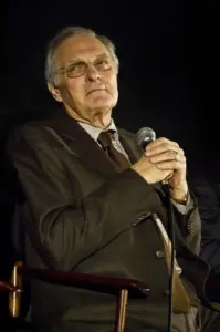 Photograph of actor Alan Alda smiling warmly and speaking during a public question-and-answer event.
