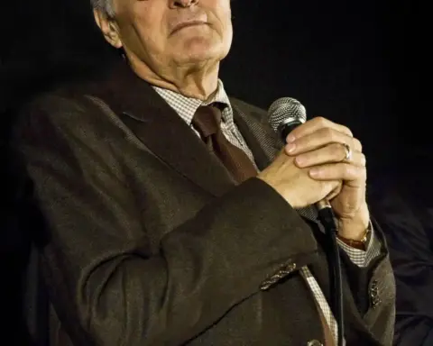 Photograph of actor Alan Alda smiling warmly and speaking during a public question-and-answer event.