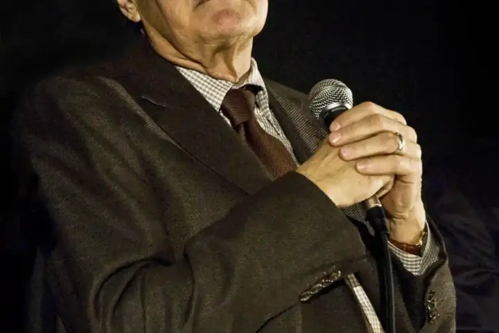 Photograph of actor Alan Alda smiling warmly and speaking during a public question-and-answer event.