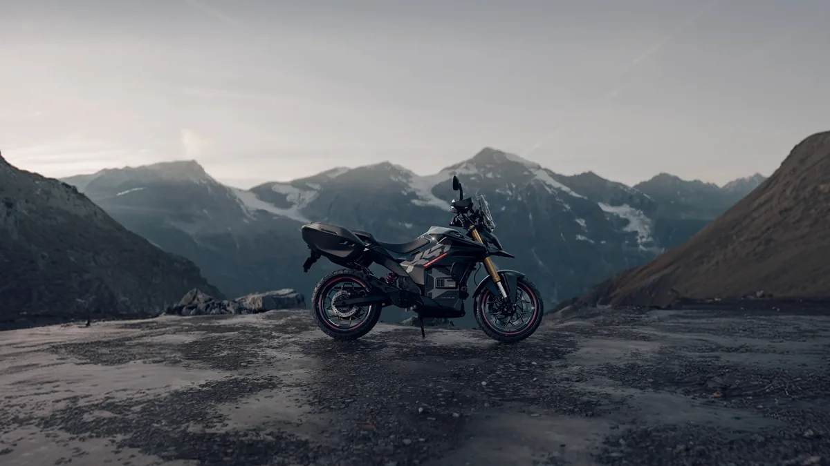 Side profile of the Ultraviolette X-47 electric motorcycle parked on a mountain pass
