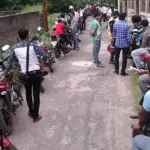 Riders and motorcycles lined up for a two-wheeler driving test at an Indian regional transport office ground