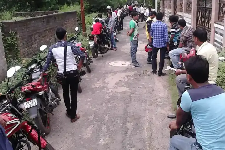Riders and motorcycles lined up for a two-wheeler driving test at an Indian regional transport office ground