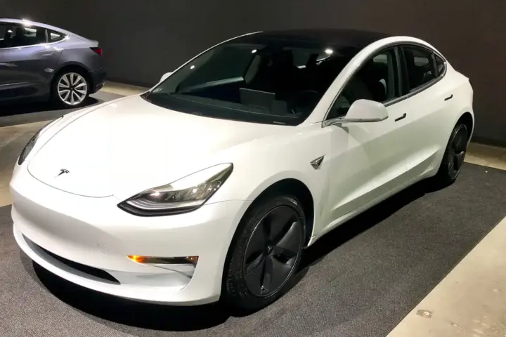 White Tesla Model 3 electric sedan photographed indoors.