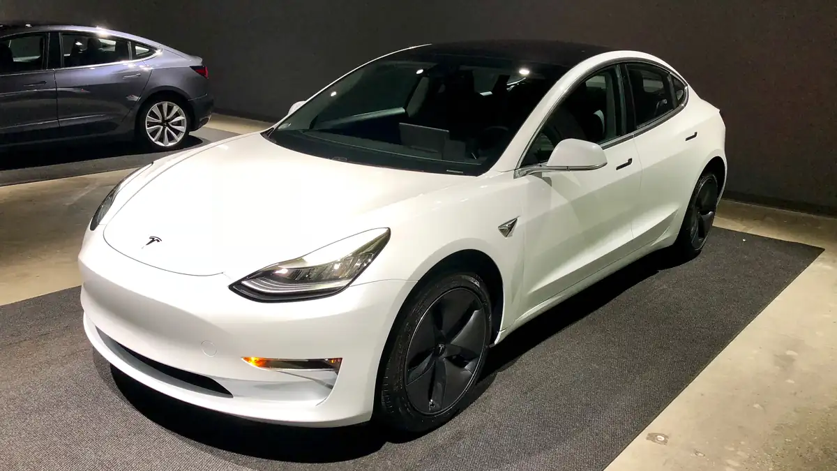 White Tesla Model 3 electric sedan photographed indoors.
