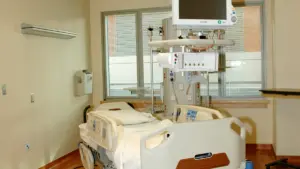 Empty hospital patient room with a single bed.