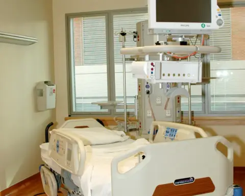 Empty hospital patient room with a single bed.