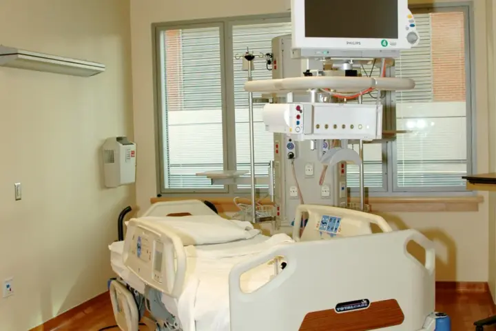 Empty hospital patient room with a single bed.