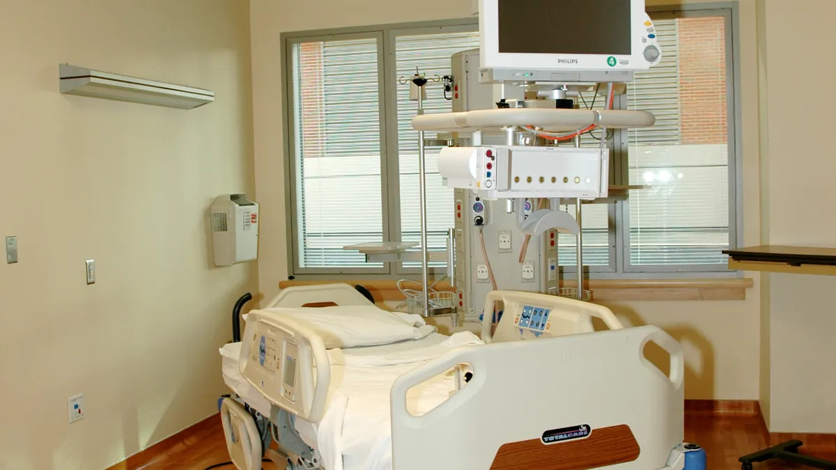 Empty hospital patient room with a single bed.
