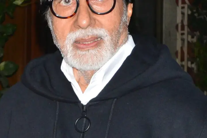 Indian actor Amitabh Bachchan photographed in close-up wearing a dark hooded jacket
