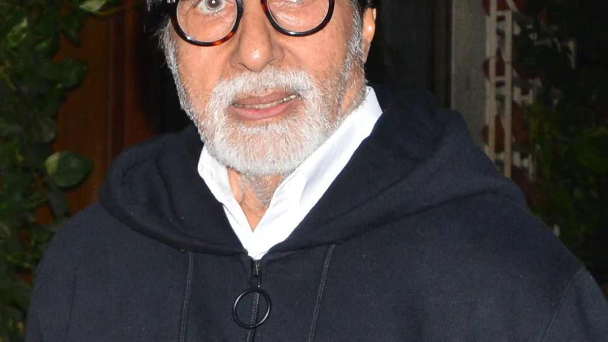 Indian actor Amitabh Bachchan photographed in close-up wearing a dark hooded jacket