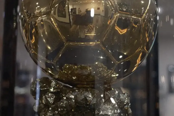 Close-up of the Ballon d'Or trophy on display at an award ceremony with ceremony lighting
