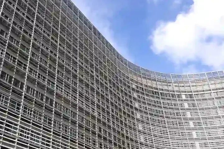 Wide-angle photograph of the glass-and-steel facade of the European Commission Berlaymont building under daylight in Brussels.