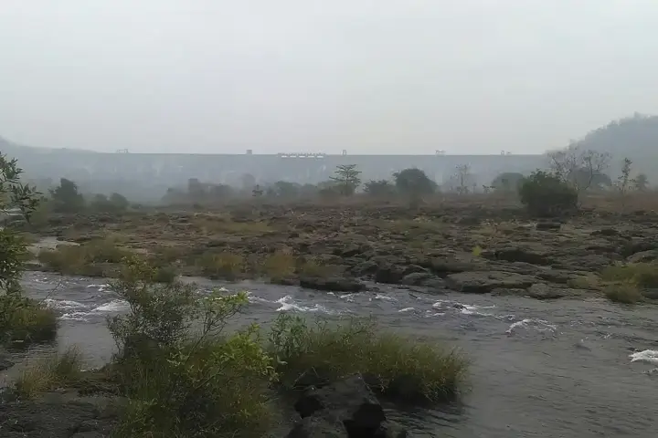 Elevated landscape photograph showing the concrete crest and water reservoir storage behind Bhatsa Dam in Thane district, Maharashtra.