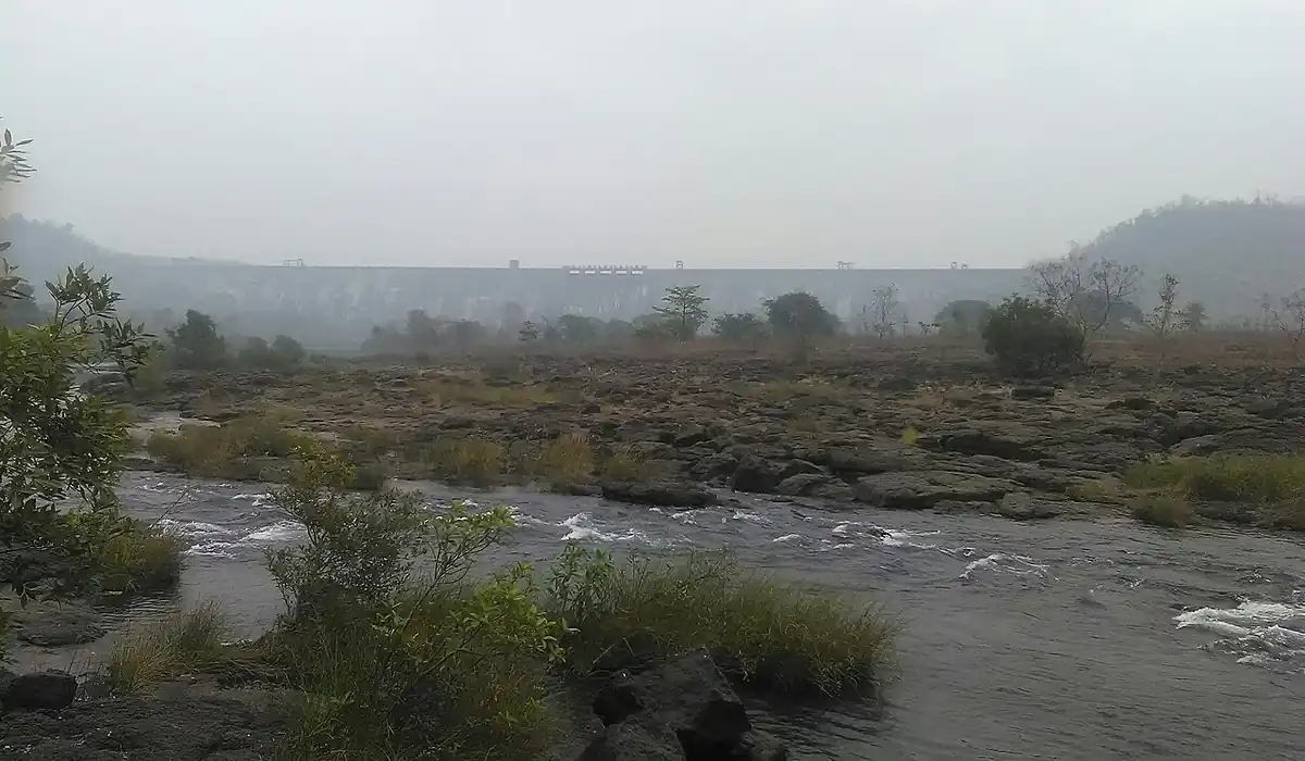 Elevated landscape photograph showing the concrete crest and water reservoir storage behind Bhatsa Dam in Thane district, Maharashtra.