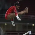 Simone Biles performing a release move on the uneven bars during training at the Rio 2016 Olympics