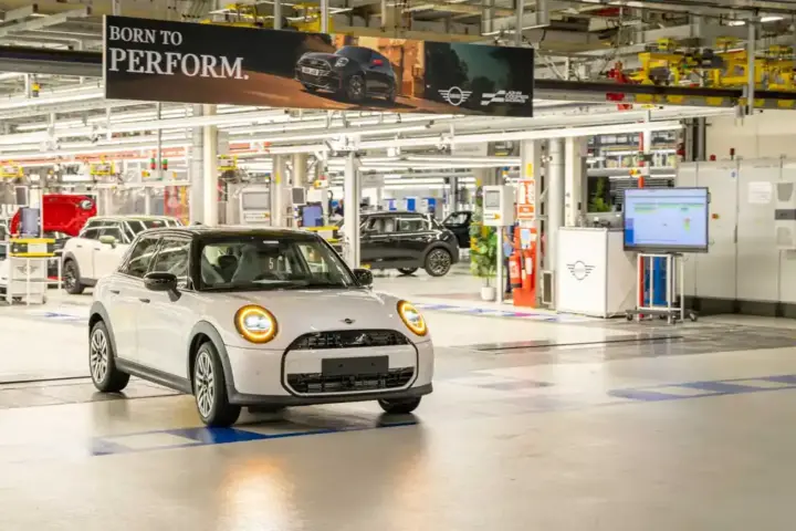 Photograph of a white MINI vehicle navigating the assembly factory floor without a driver at MINI Plant Oxford