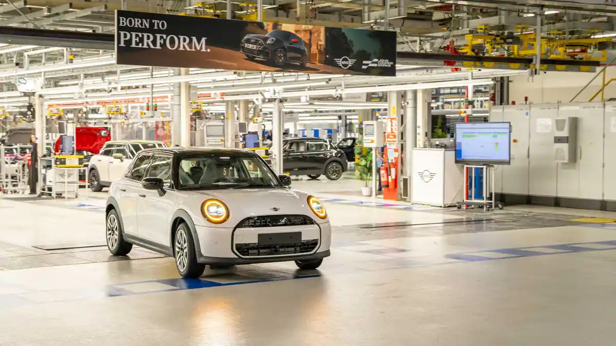 Photograph of a white MINI vehicle navigating the assembly factory floor without a driver at MINI Plant Oxford