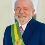 Official presidential portrait photograph of Brazilian President Luiz Inácio Lula da Silva wearing a dark suit and the green and yellow presidential sash.