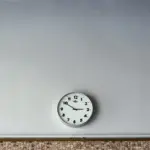 Close-up of a round analog wall clock face with clean hour numerals and dark hands.