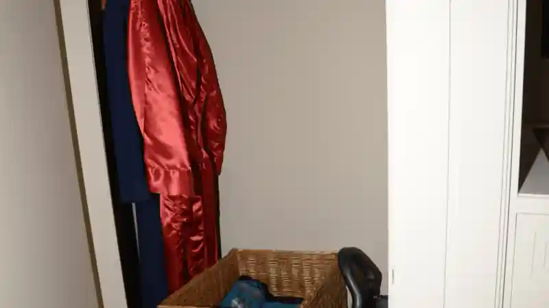 A wardrobe with hanging garments and a basket of folded clothing.