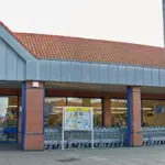 Exterior view of a single-storey Lidl supermarket building and customer car park in Barton-upon-Humber, England.