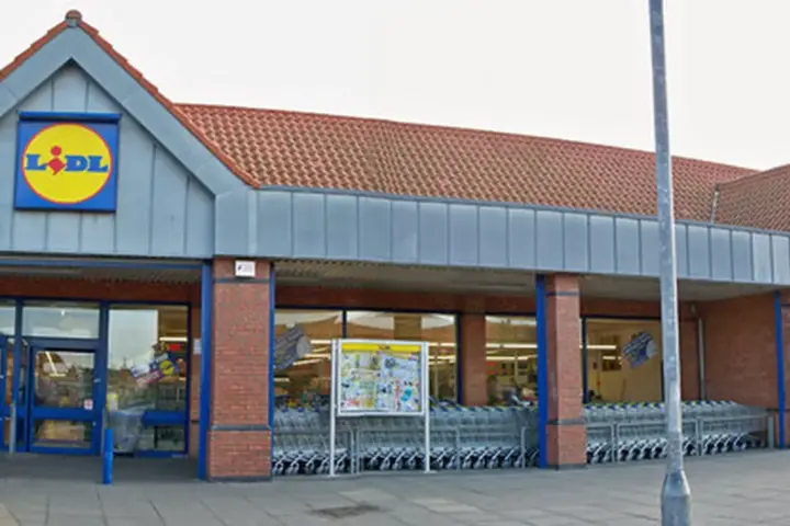 Exterior view of a single-storey Lidl supermarket building and customer car park in Barton-upon-Humber, England.