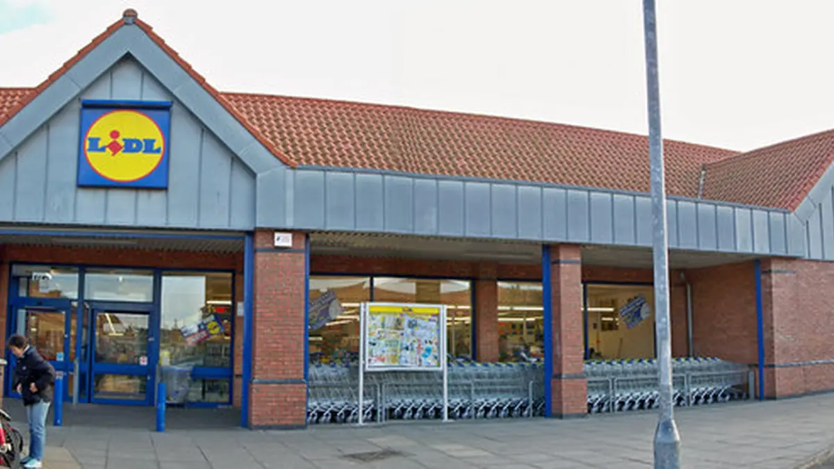 Exterior view of a single-storey Lidl supermarket building and customer car park in Barton-upon-Humber, England.